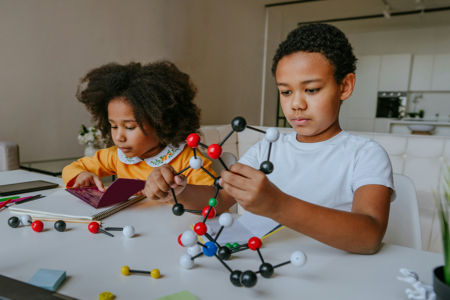A boy and girl playing with a STEAM build set