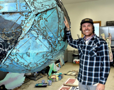 Seth Weber poses next to an in-progress sculpture