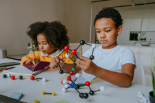 A boy and girl playing with a STEAM build set