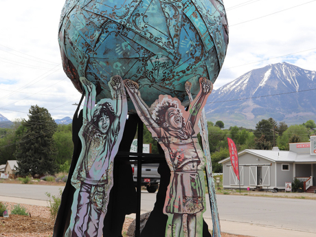 A metal sculpture depicting several children holding up the world globe. 