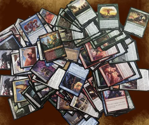Image of a variety of game cards from Magic: The Gathering, spread across a table.