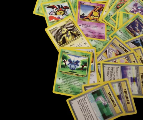 Image of many Pokémon Cards spread across a table.