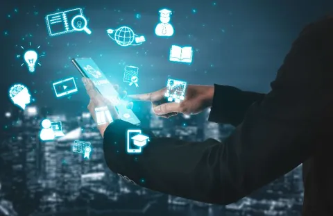 Person using tablet or phone with symbols of educational use.