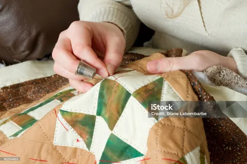 a woman sews a quilt