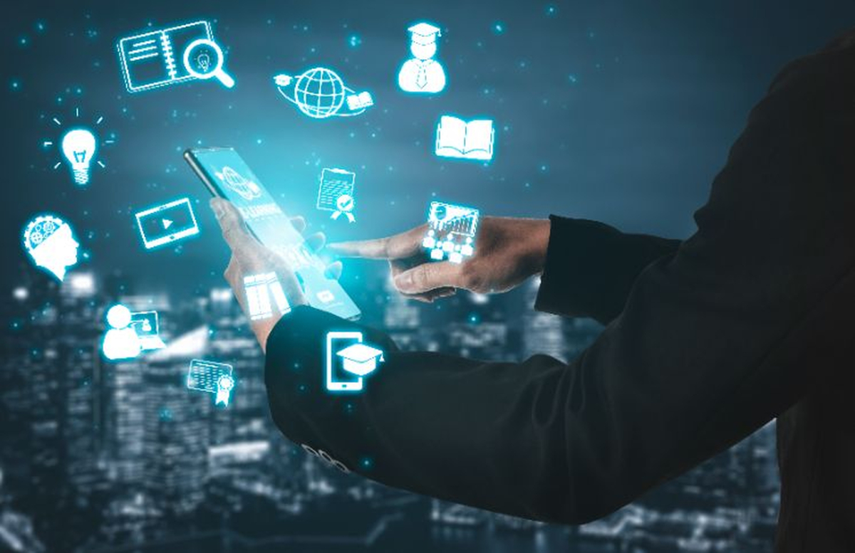 Person using tablet or phone with symbols of educational use.